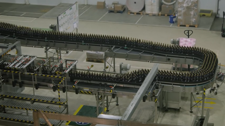 Glass Bottles Transported on a Conveyor Belt in a Brewery